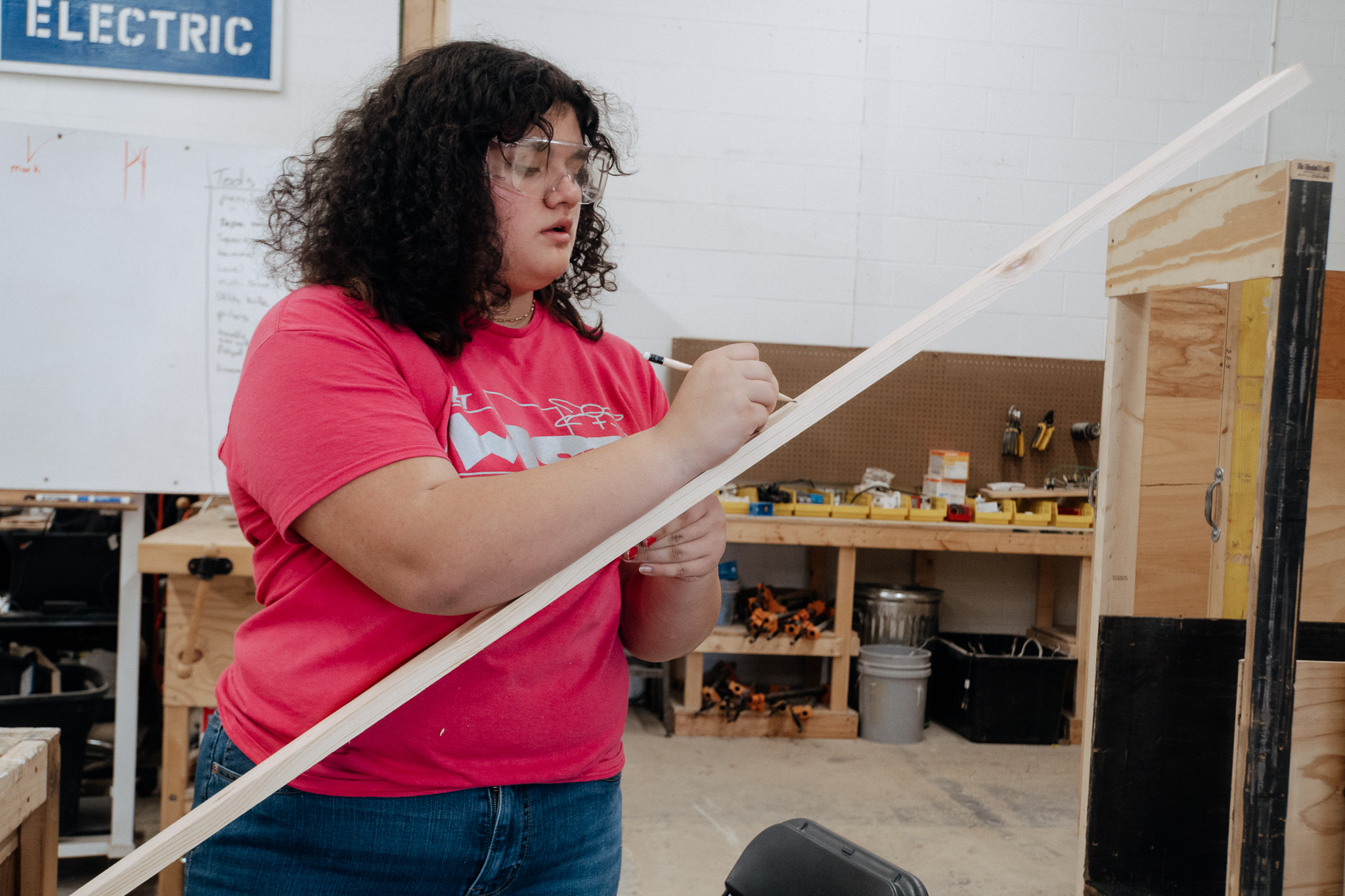 Student measuring lumber in construction class
