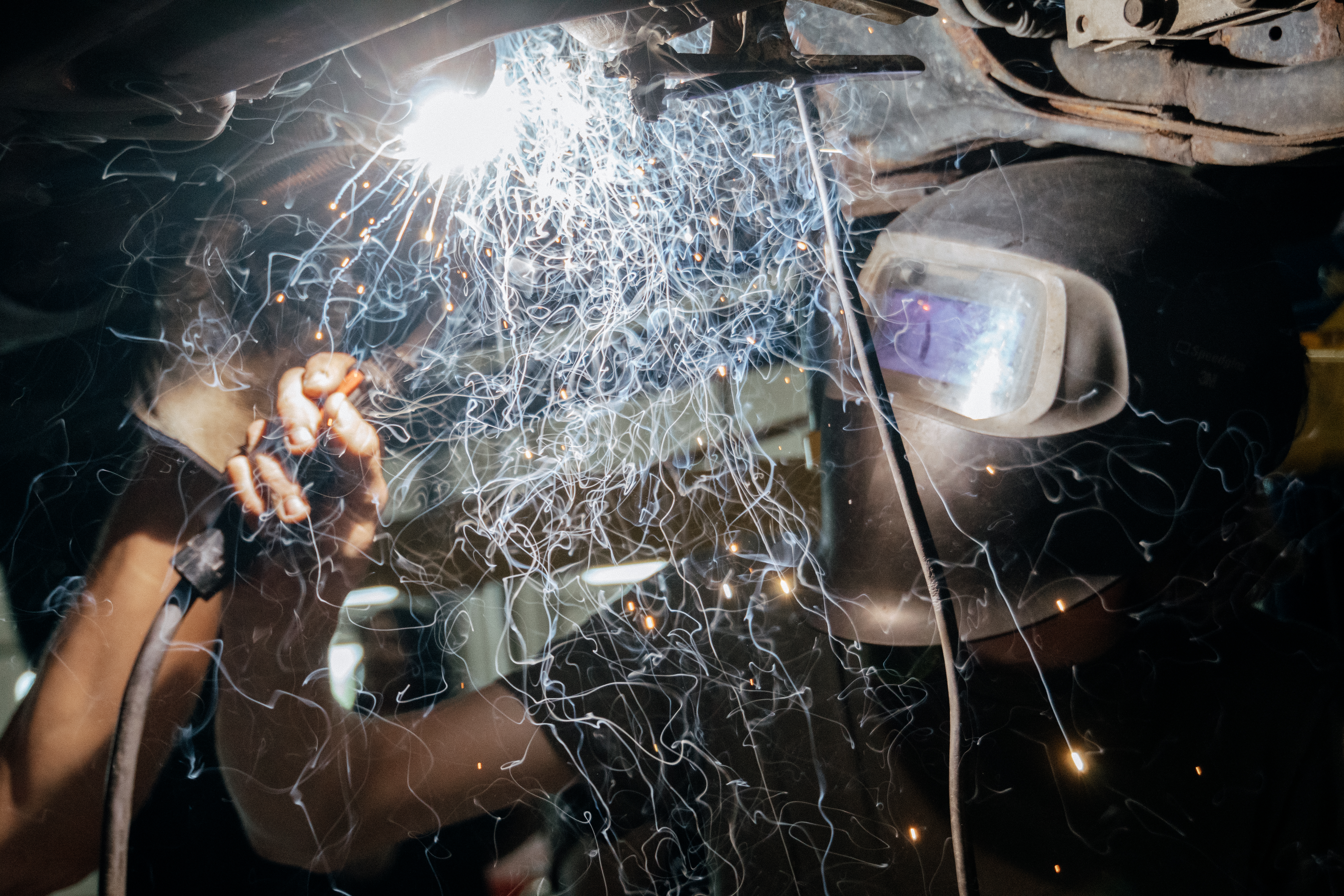 Student welding with sparks flying